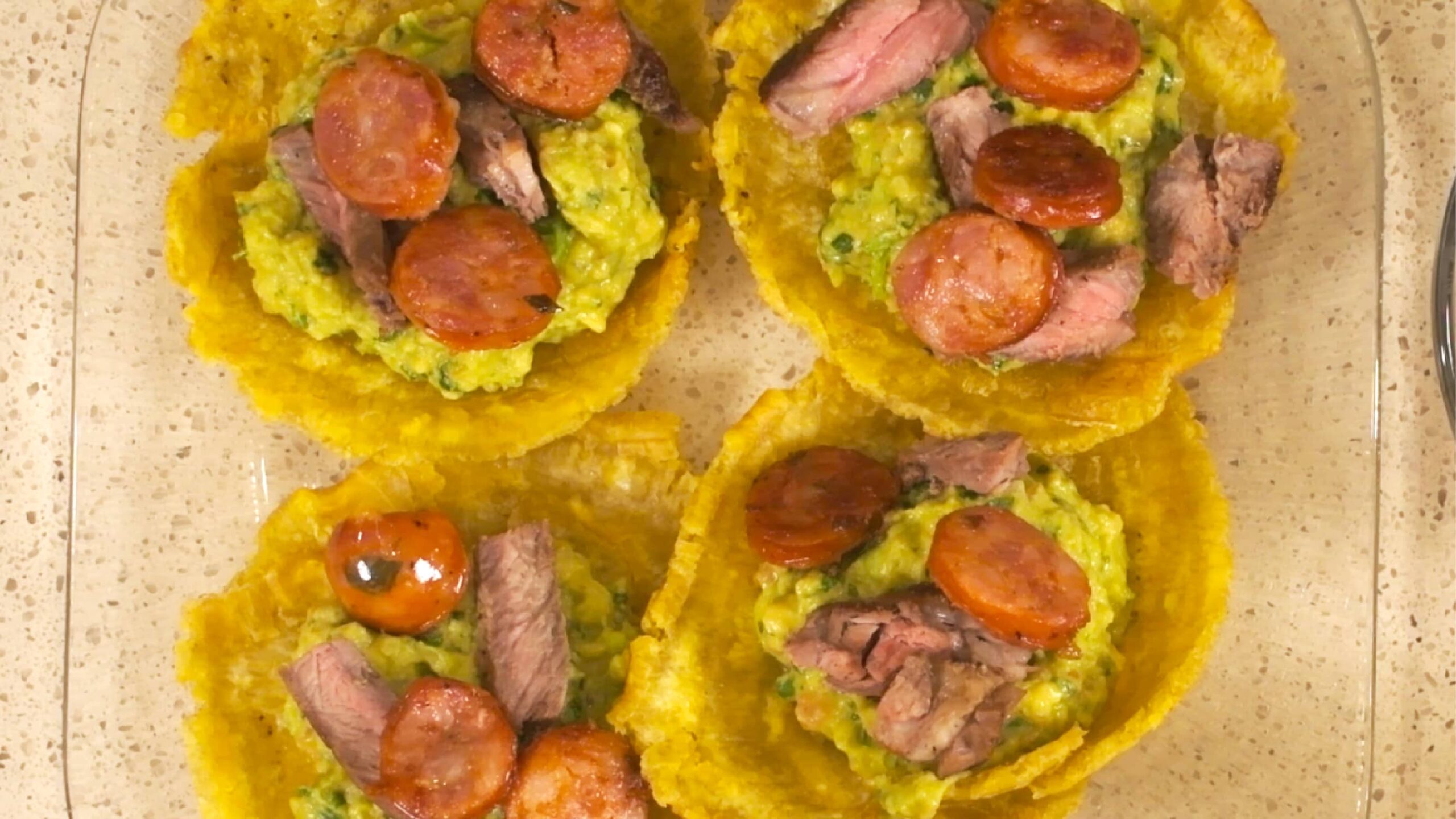 Concave Patacones Stuffed with Guacamole, Meat, and Sausage